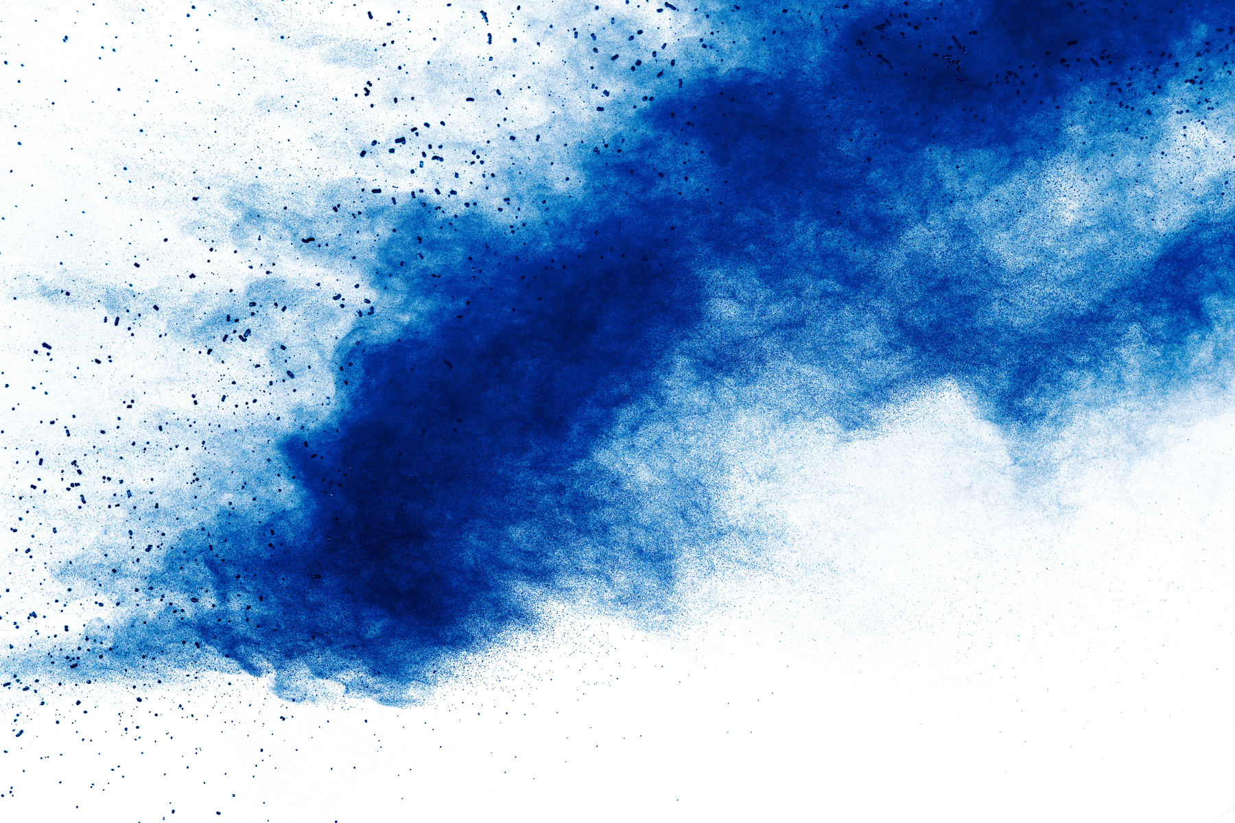 Abstract blue dust explosion on white background. Freeze motion of blue holi powder splash.